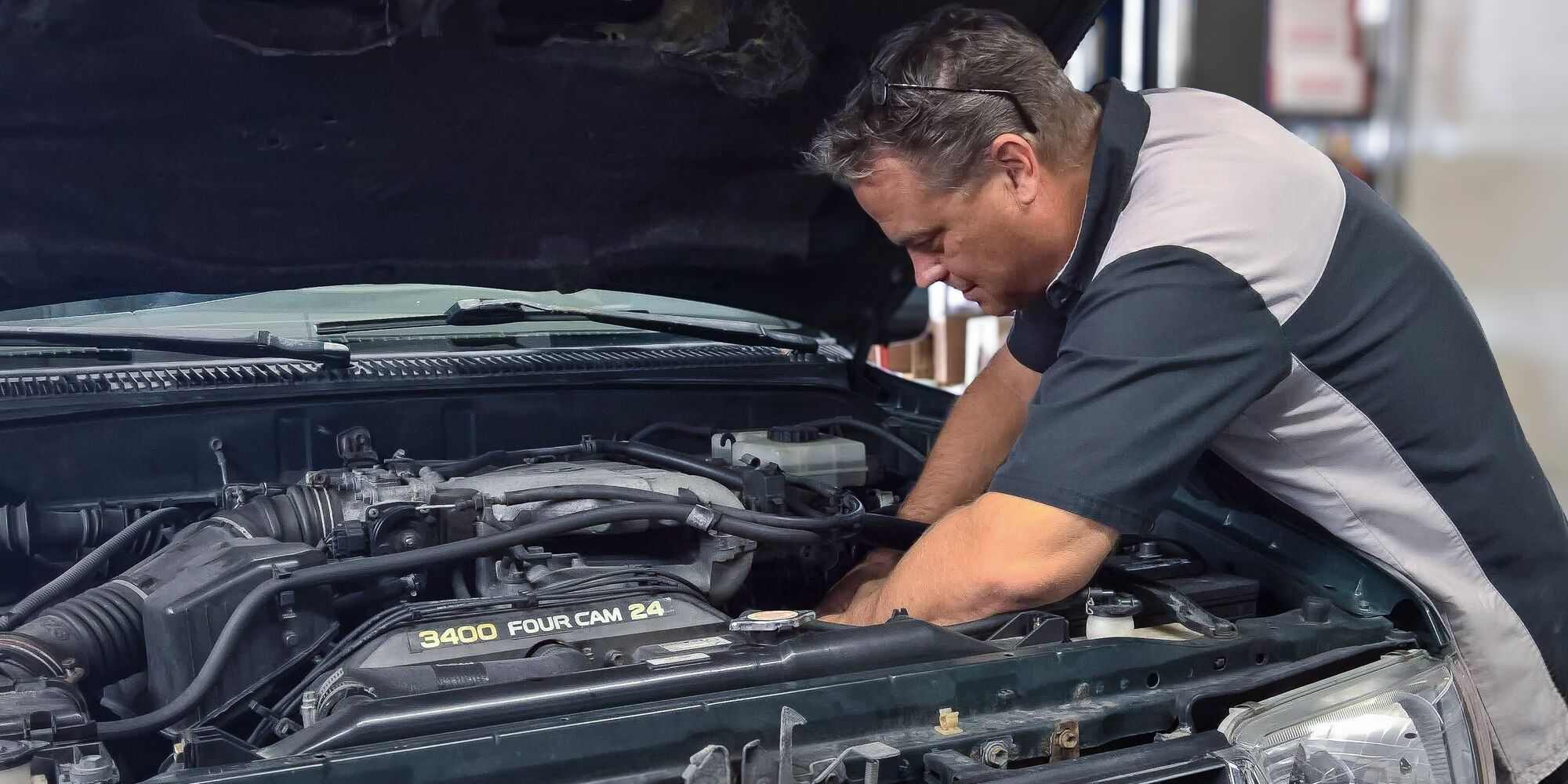 ASE-certified technician servicing an engine under the hood at Master Team Automotive