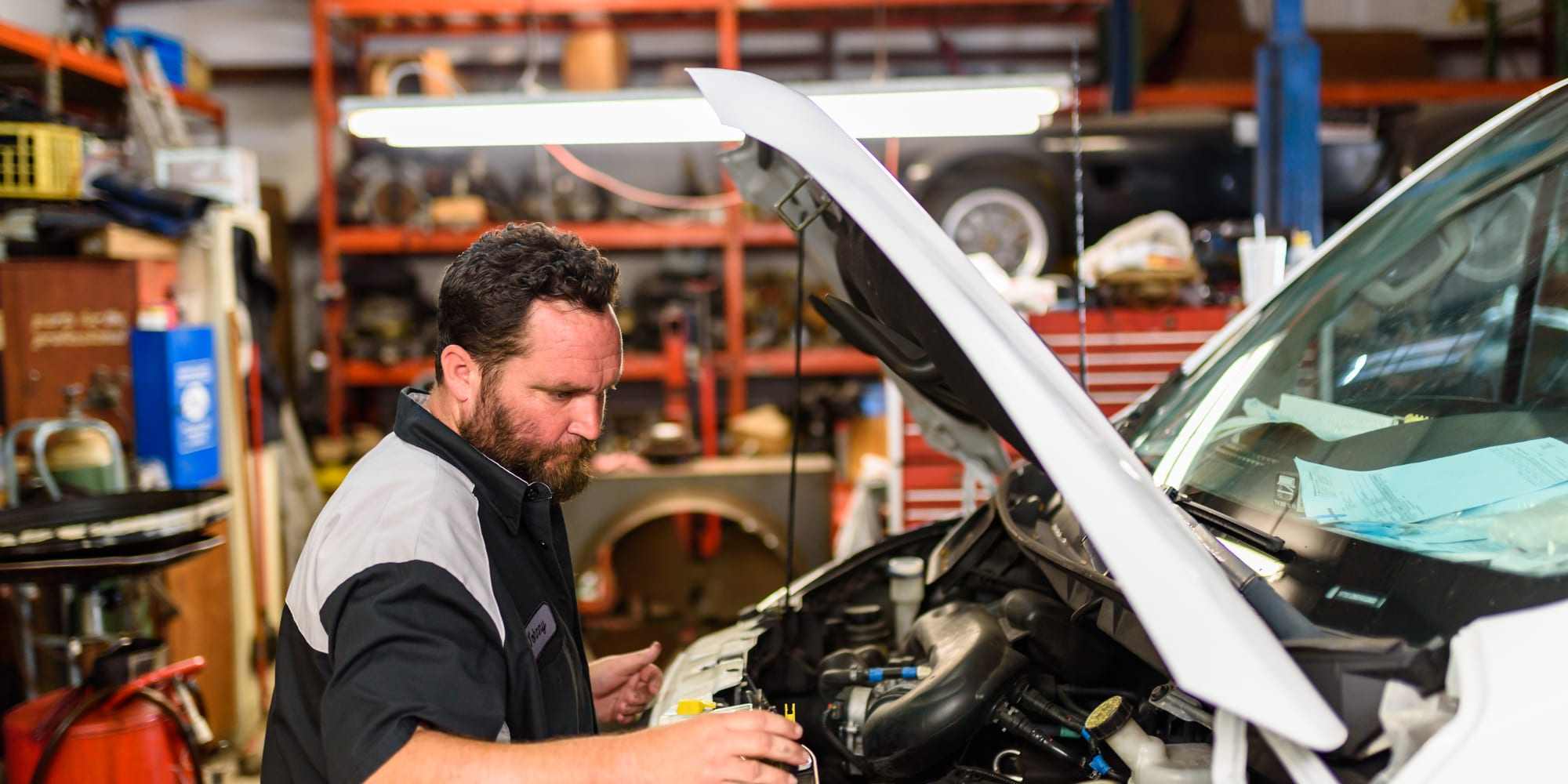 A technician working on an engine during a tune-up