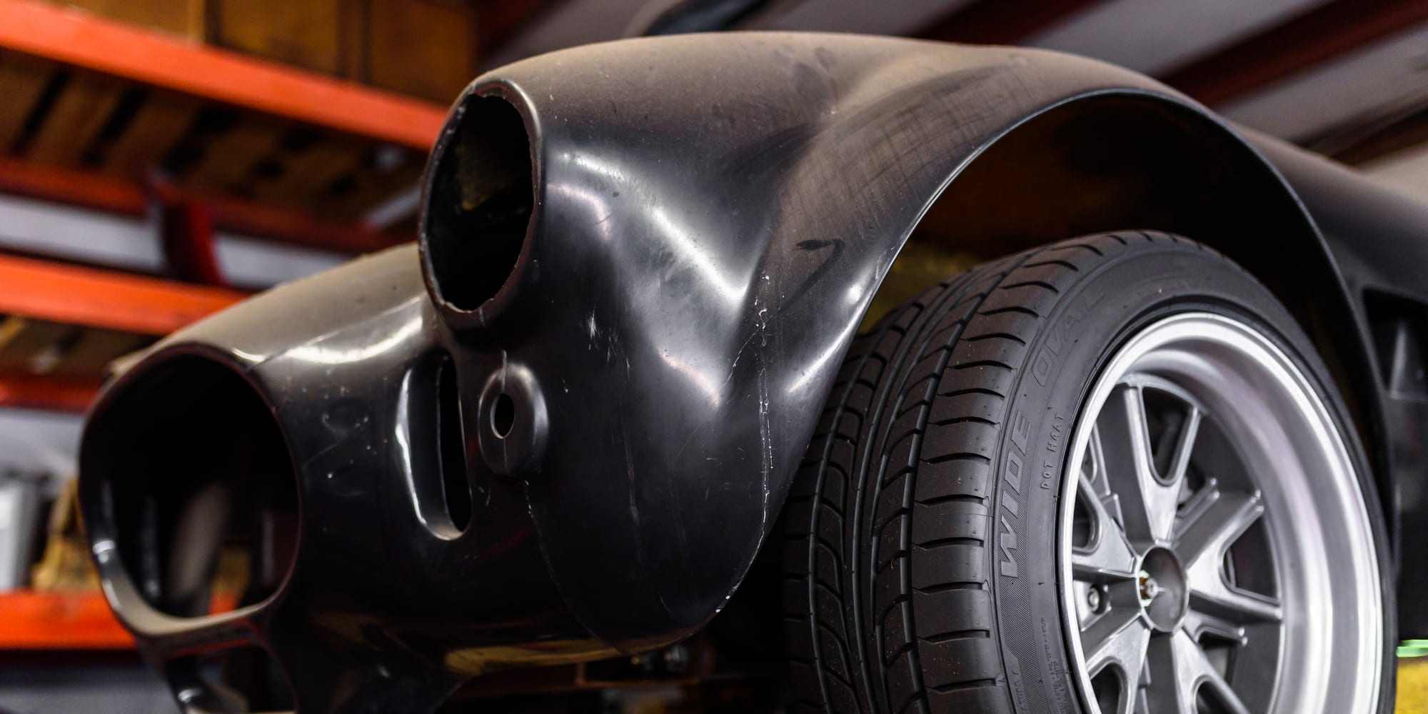 A close-up of a vehicle's wheel and tire in the shop
